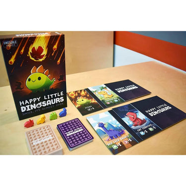 Happy Little Dinosaurs party game by Unstable Games featuring colorful dinosaur illustrations and game components on a table.