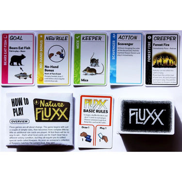Family game of Nature Fluxx by Looney Labs featuring colorful card decks and nature-themed gameplay elements.