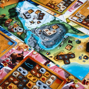 Family game Prehistories by The Flying Games featuring colorful dinosaur-themed cards and game pieces on a wooden surface.