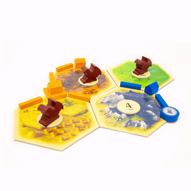 Catan: Treasures, Dragons & Adventurers family game box featuring colorful artwork and game components laid out.