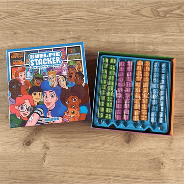 Arkush Games Shelfie Stacker family game with colorful wooden blocks stacked on a table, demonstrating play and balance.