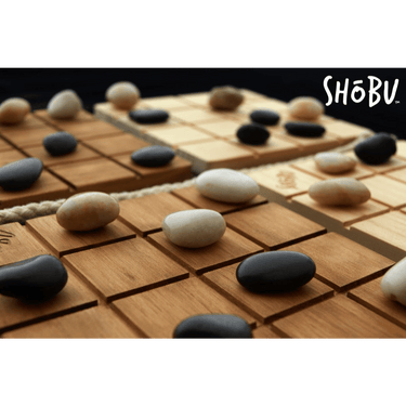 Abstract strategy game Shōbu by Smirk & Laughter Games, showing a wooden game board with black and white stones in play.